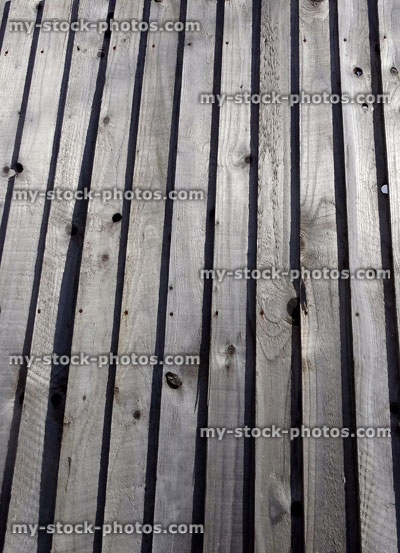 Stock image of wooden featherboard fence, timber feather edge fencing panels