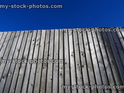 Stock image of wooden featherboard fence, pre treated feather edge timber fencing panels