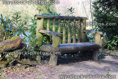 Stock image of rustic bench, wooden log seat, homemade garden furniture