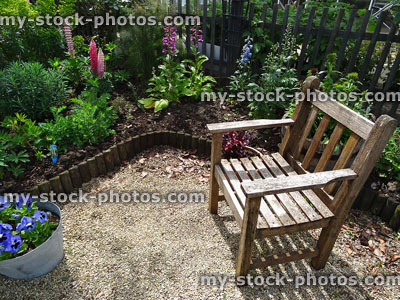 Stock image of wooden garden chair, herbaceous flowers, lupins, foxgloves, delphiniums