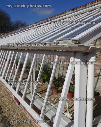 Stock image of large wooden glasshouse / greenhouse with plants, glass windows