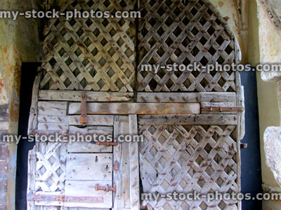 Stock image of historic medieval wooden doors in archway, lattice pattern
