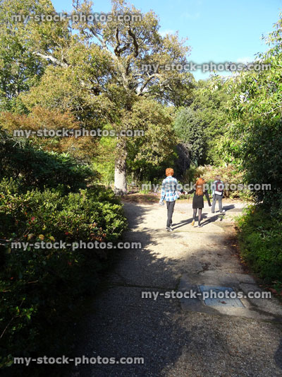 Stock image of children running along pathway, sunny woodland, dappled shade / shadows, path