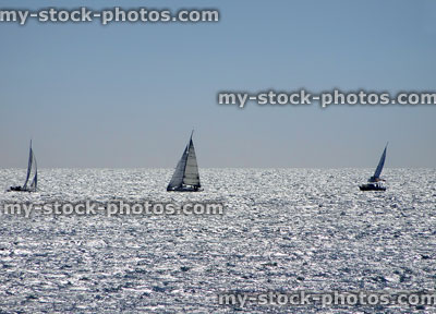 Stock image of yachts sailing on sparkling sea waves in distance